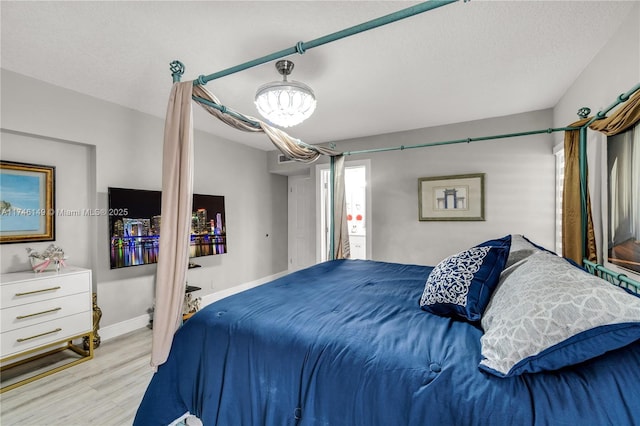 bedroom featuring light hardwood / wood-style flooring and a textured ceiling