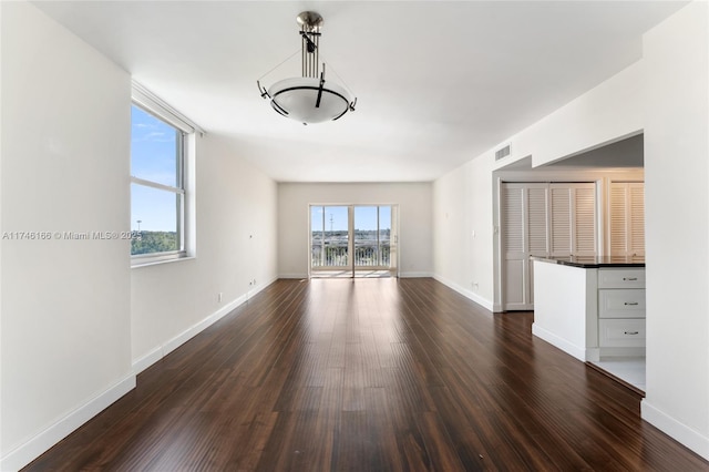 unfurnished living room with dark hardwood / wood-style floors