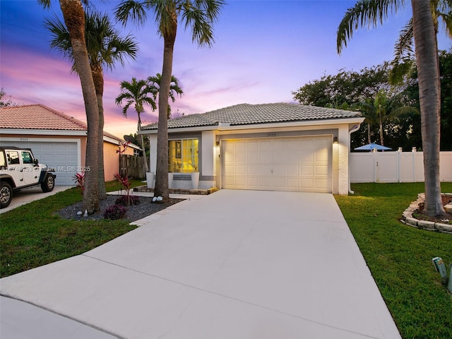 view of front of property featuring a garage and a lawn