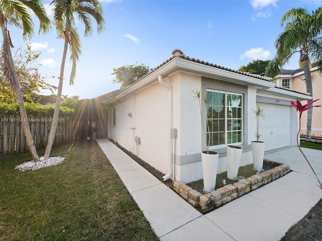 view of side of home with a garage and a lawn