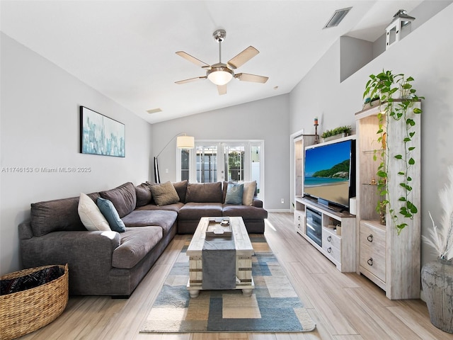 living room with light hardwood / wood-style flooring, french doors, ceiling fan, and vaulted ceiling