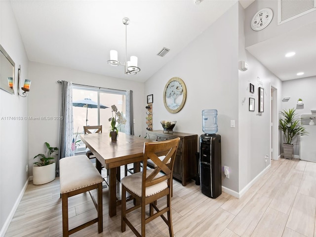 dining space featuring light hardwood / wood-style floors, vaulted ceiling, and a notable chandelier