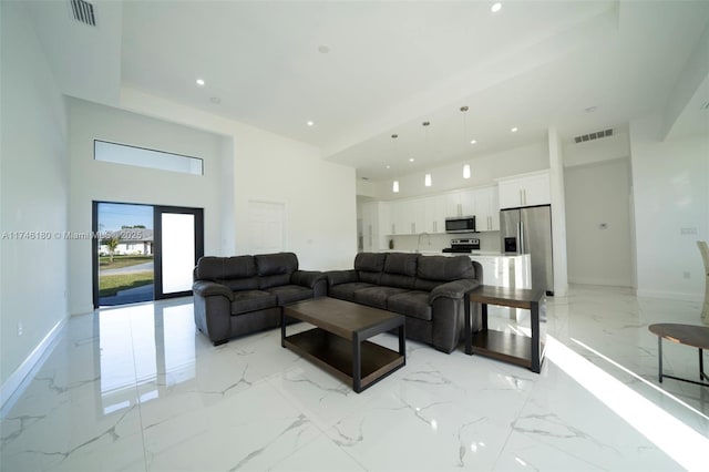 living room featuring sink and a high ceiling