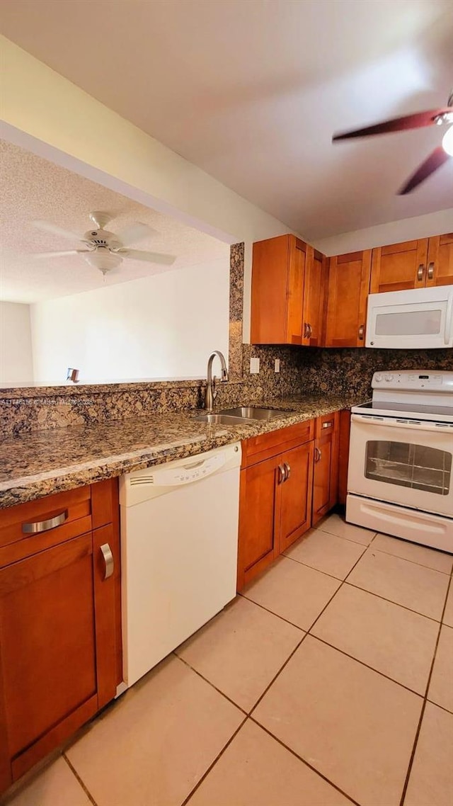 kitchen with sink, white appliances, light tile patterned floors, ceiling fan, and decorative backsplash