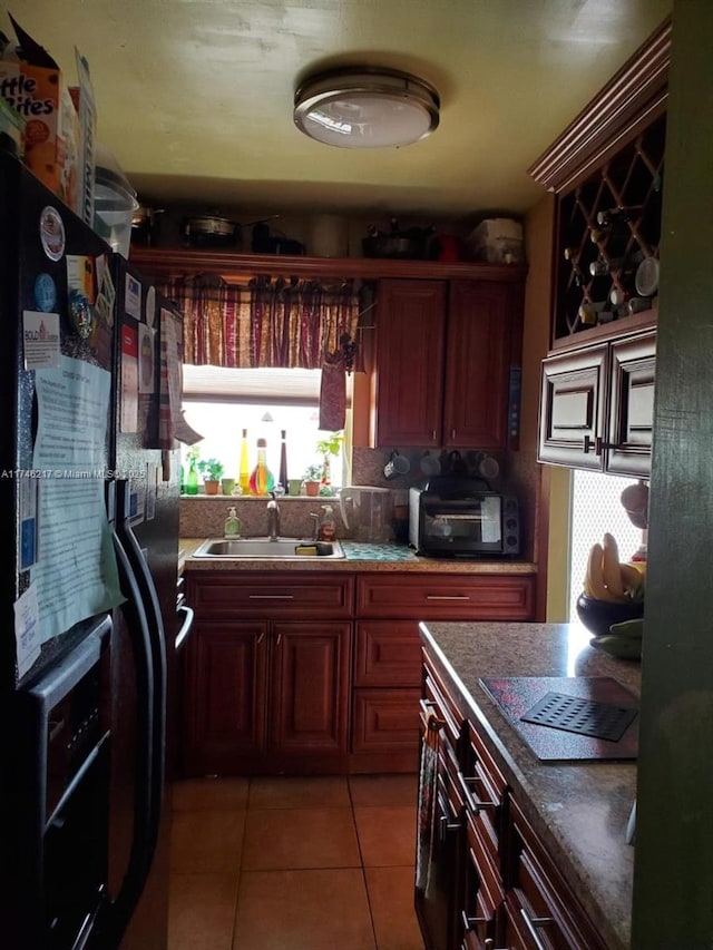 kitchen with backsplash, black fridge with ice dispenser, sink, and light tile patterned floors