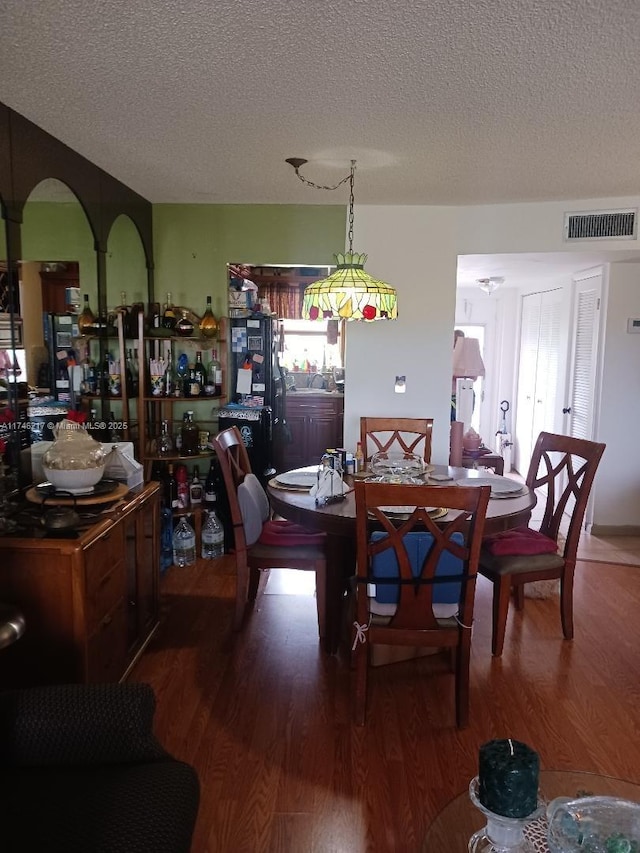 dining space featuring hardwood / wood-style floors and a textured ceiling