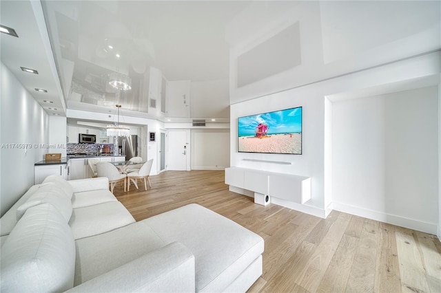 living room with light hardwood / wood-style flooring and a notable chandelier