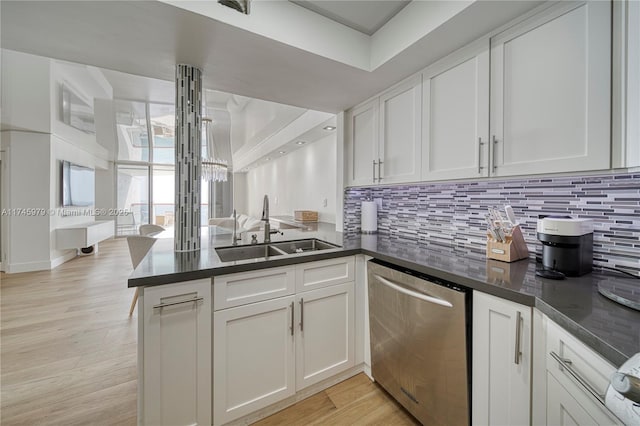 kitchen featuring dishwasher, sink, kitchen peninsula, and white cabinets