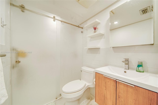 bathroom with vanity, toilet, tile walls, and decorative backsplash