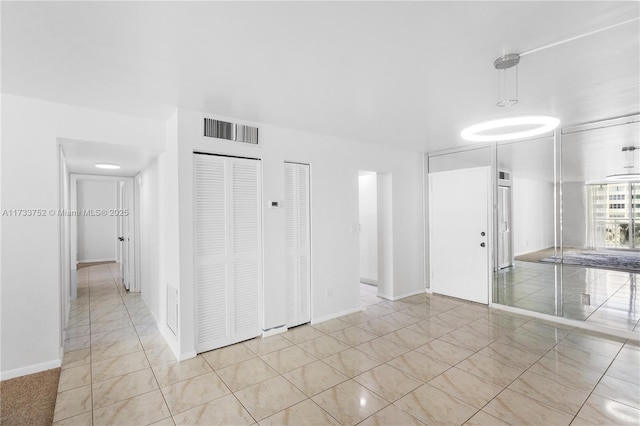 unfurnished room with baseboards and visible vents