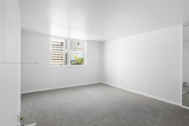 carpeted empty room featuring baseboards