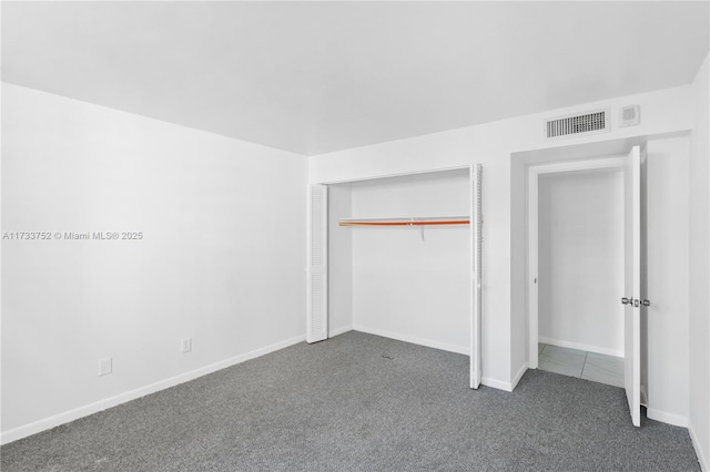 unfurnished bedroom with baseboards, visible vents, a closet, and carpet floors