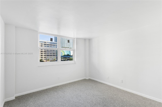 unfurnished room featuring baseboards and carpet floors