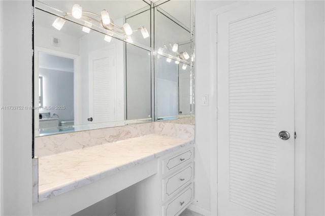 bathroom with vanity and a closet
