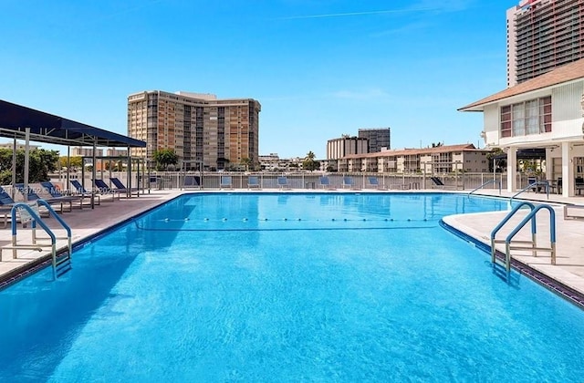 community pool with fence and a patio area