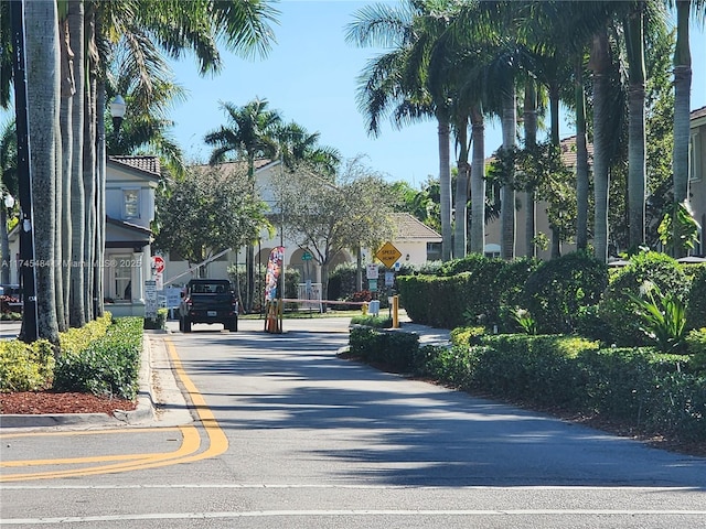 view of road featuring traffic signs, curbs, and street lights