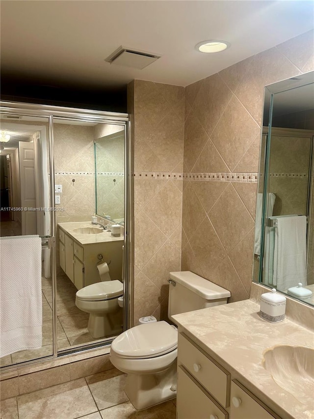 bathroom featuring vanity, tile walls, tile patterned floors, and toilet