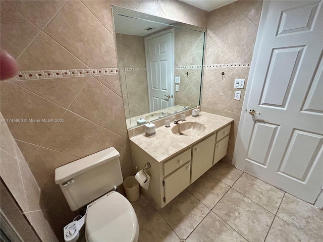 bathroom featuring tile walls, vanity, tile patterned floors, and toilet