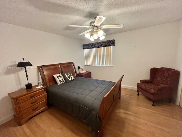 bedroom featuring ceiling fan, light hardwood / wood-style flooring, and a textured ceiling