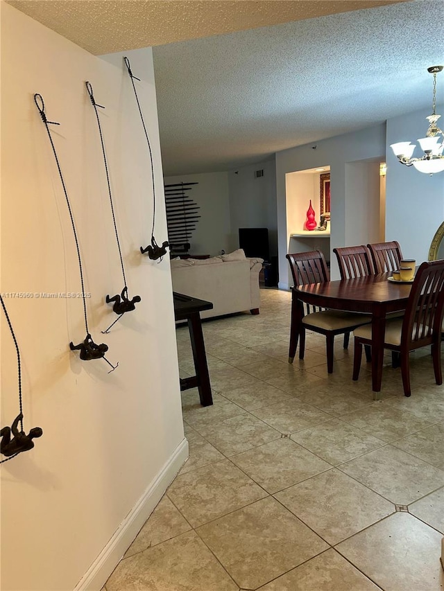 dining space with light tile patterned flooring, a notable chandelier, and a textured ceiling