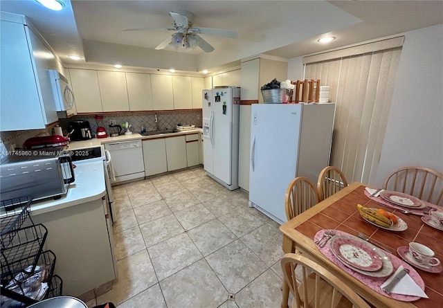 kitchen featuring sink, white appliances, light tile patterned floors, ceiling fan, and backsplash