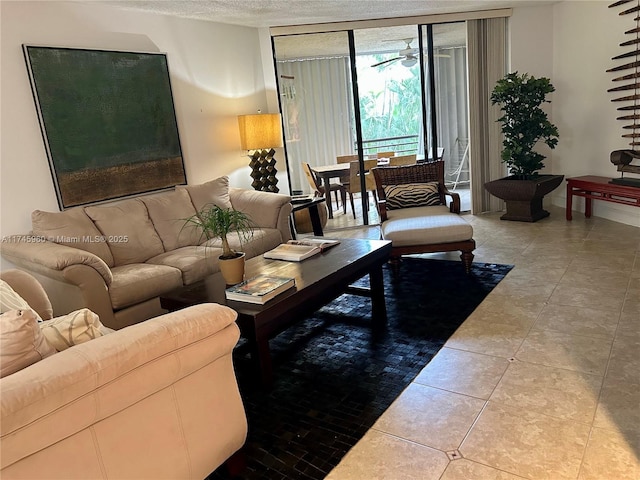 living room with ceiling fan, a textured ceiling, and light tile patterned floors