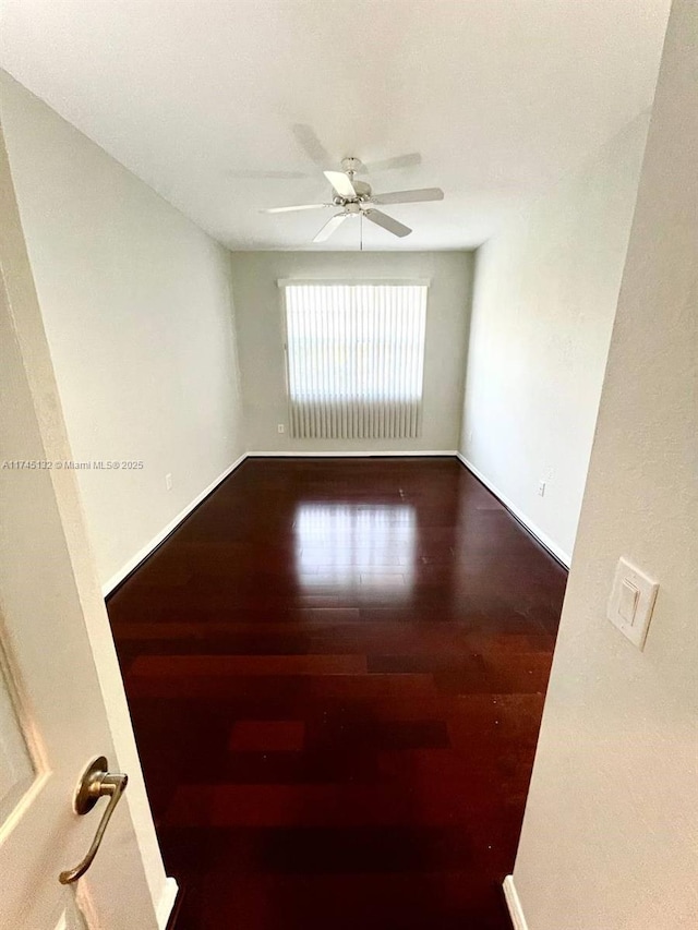unfurnished room with ceiling fan and dark hardwood / wood-style flooring