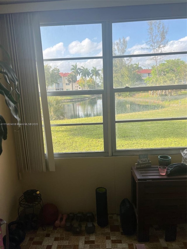 sunroom / solarium featuring a water view