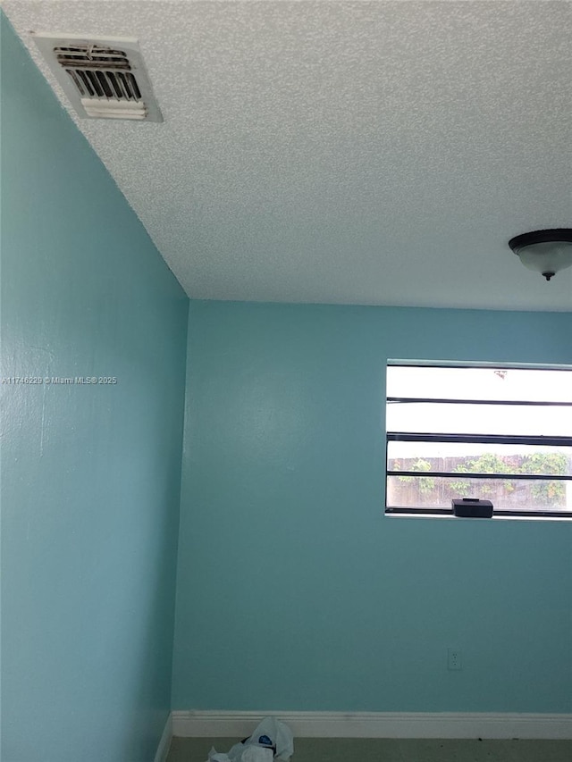 unfurnished room featuring a textured ceiling