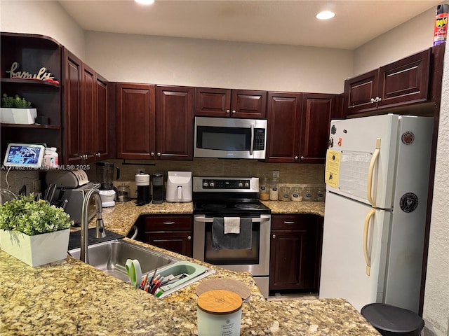 kitchen with tasteful backsplash, sink, stainless steel appliances, and light stone countertops