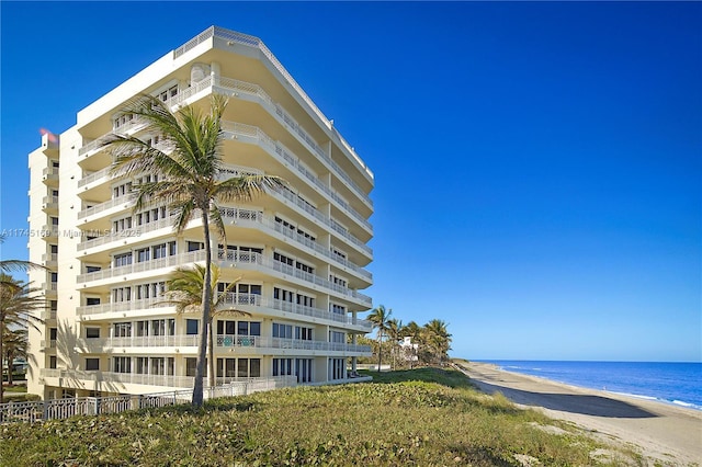 view of building exterior featuring a water view and a view of the beach