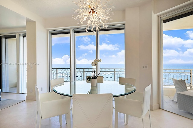 dining room featuring a chandelier and a water view