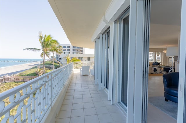 balcony featuring a beach view and a water view