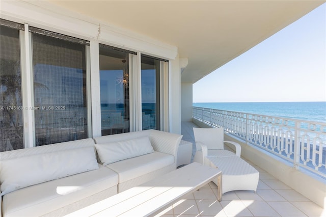 balcony featuring a water view and an outdoor living space