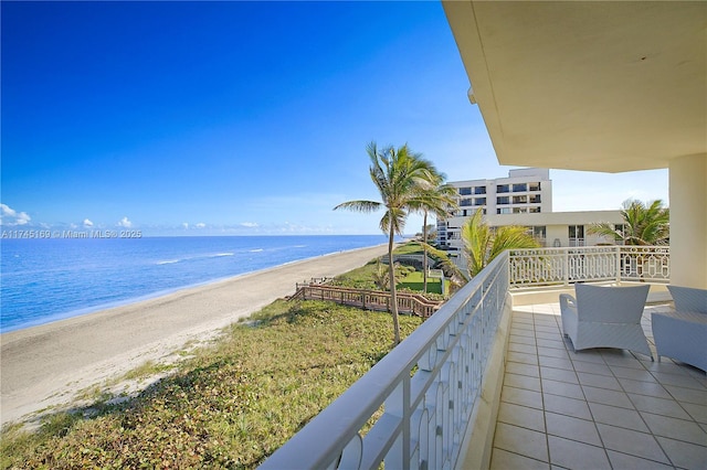 balcony with a water view and a beach view