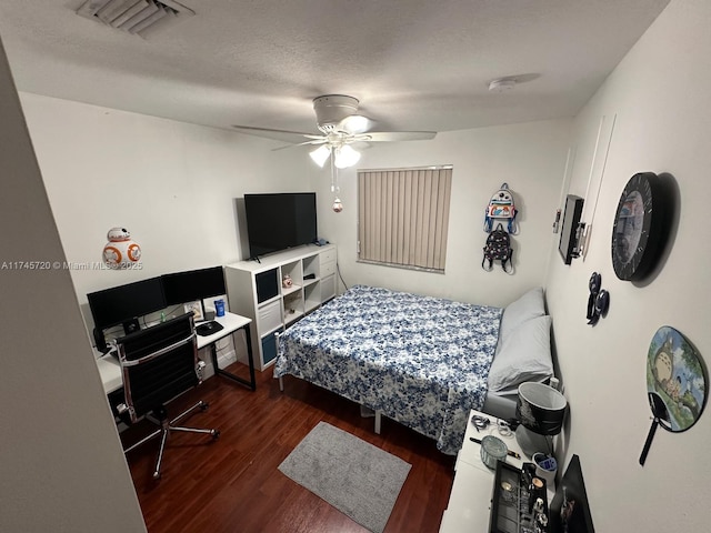 bedroom featuring ceiling fan, dark hardwood / wood-style floors, and a textured ceiling