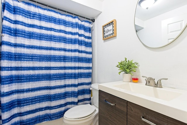 bathroom with vanity, curtained shower, and toilet