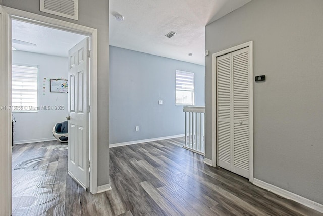 corridor featuring dark hardwood / wood-style flooring and a textured ceiling