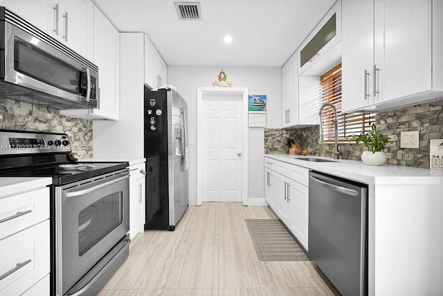 713 SW 6th Ave, Hallandale Beach, FL 33009 - kitchen with white cabinetry, sink, backsplash, and stainless steel appliances
