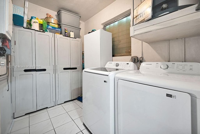 713 SW 6th Ave, Hallandale Beach, FL 33009 - washroom with cabinets, light tile patterned floors, and washer and clothes dryer