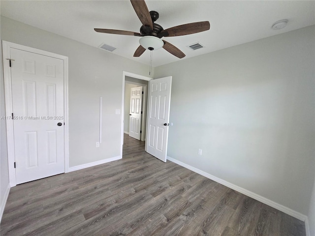 unfurnished bedroom featuring visible vents, ceiling fan, baseboards, and wood finished floors