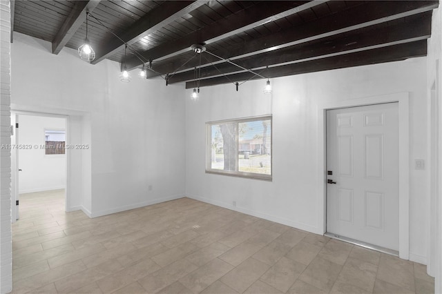 empty room featuring wood ceiling and beamed ceiling