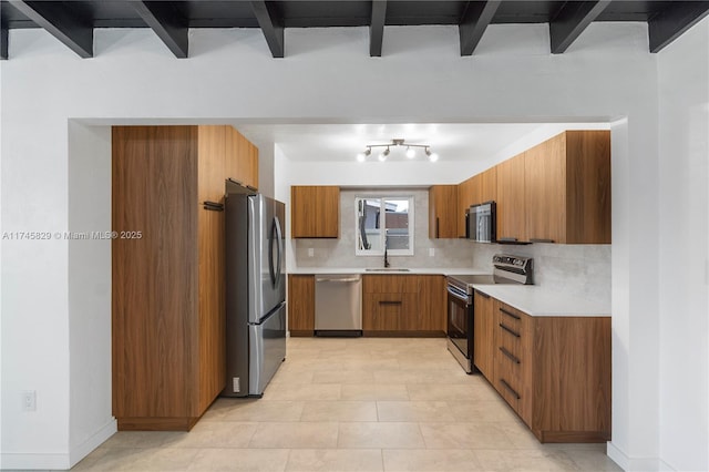 kitchen featuring stainless steel appliances, sink, beam ceiling, and decorative backsplash