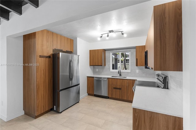 kitchen featuring light stone counters, sink, backsplash, and appliances with stainless steel finishes