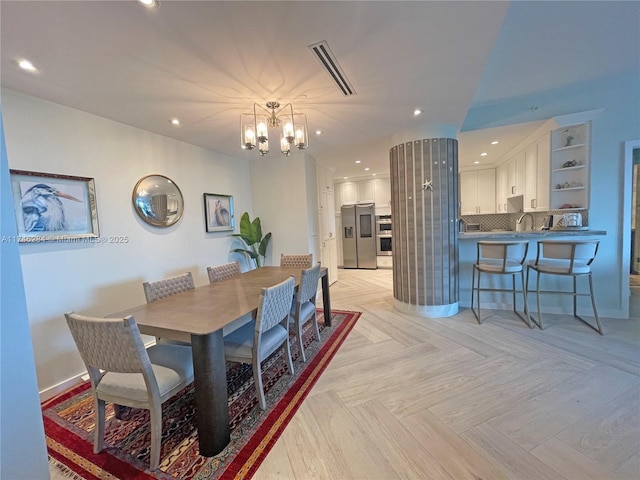 dining area featuring a notable chandelier and light parquet flooring