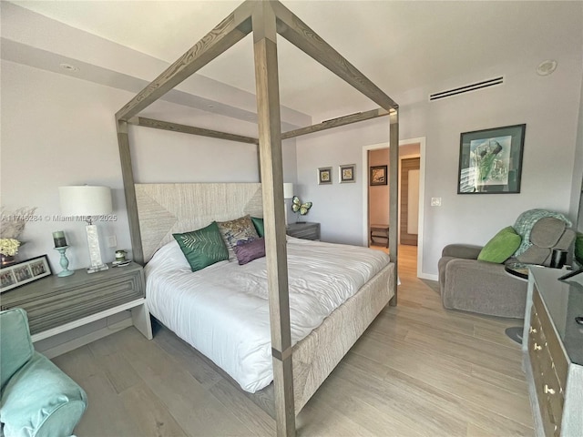 bedroom with hardwood / wood-style flooring and beamed ceiling