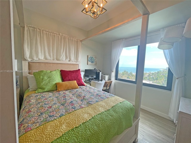 bedroom with a notable chandelier and light hardwood / wood-style flooring