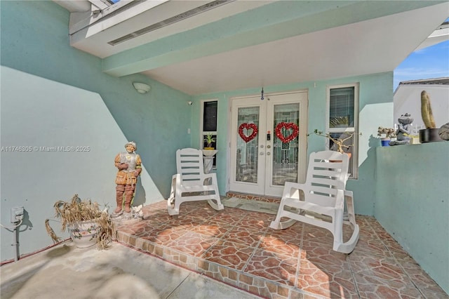 entrance to property featuring french doors, a patio area, and stucco siding