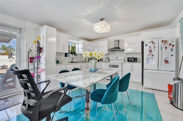 881 SW 137th Ct, Miami, FL 33184 - kitchen with white appliances, light tile patterned floors, white cabinets, decorative backsplash, and wall chimney exhaust hood