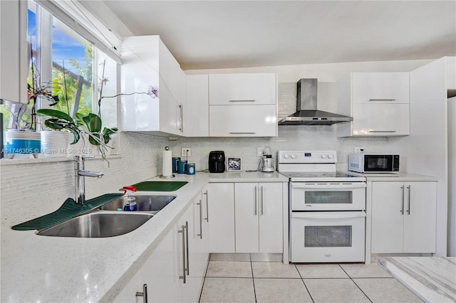 881 SW 137th Ct, Miami, FL 33184 - kitchen with white cabinets, range with two ovens, wall chimney exhaust hood, black microwave, and a sink
